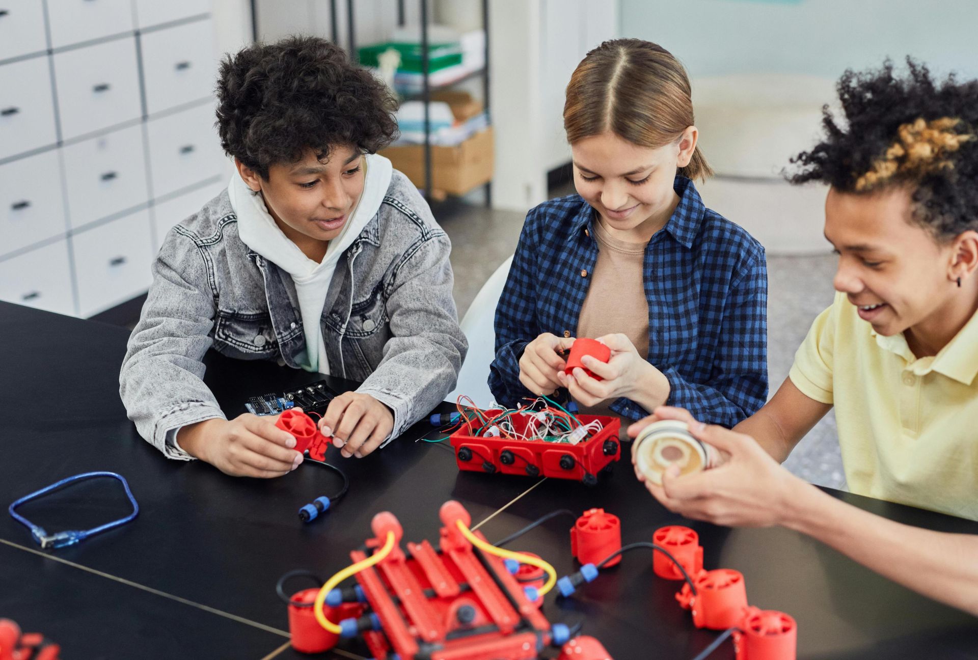 Children collaborating on a robotics project, showcasing teamwork and STEM learning indoors.